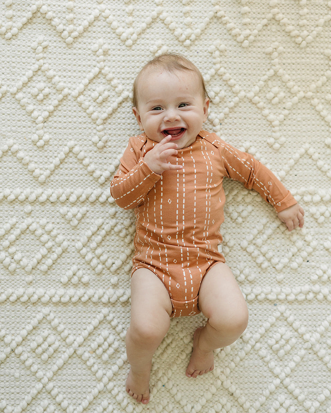 Loulou Lollipop Long Sleeve Bodysuit in Rust Geo — front view on white background